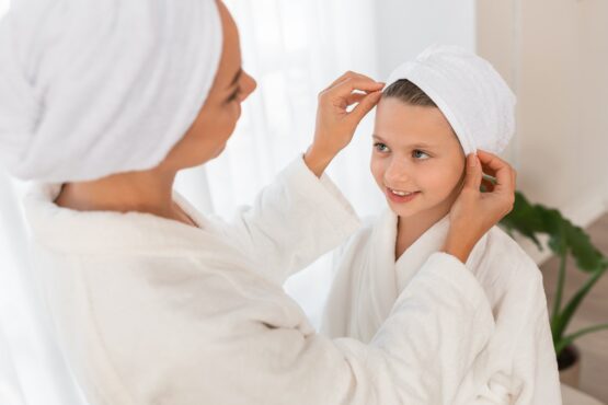 Mom Adjusting Hair Towel Wrap For Her Little Daughter,